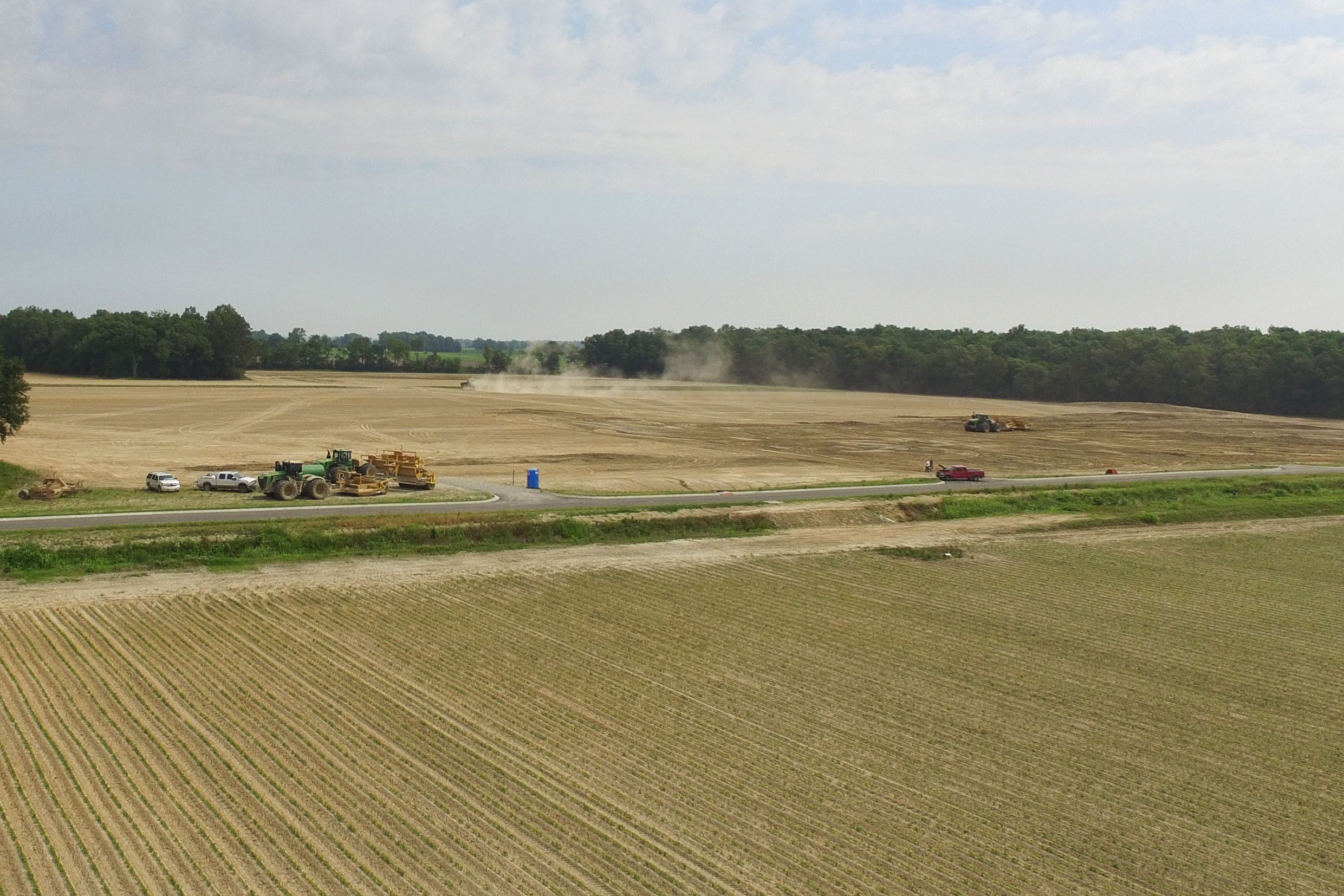 Tractors and construction vehicles in field of dirt working.