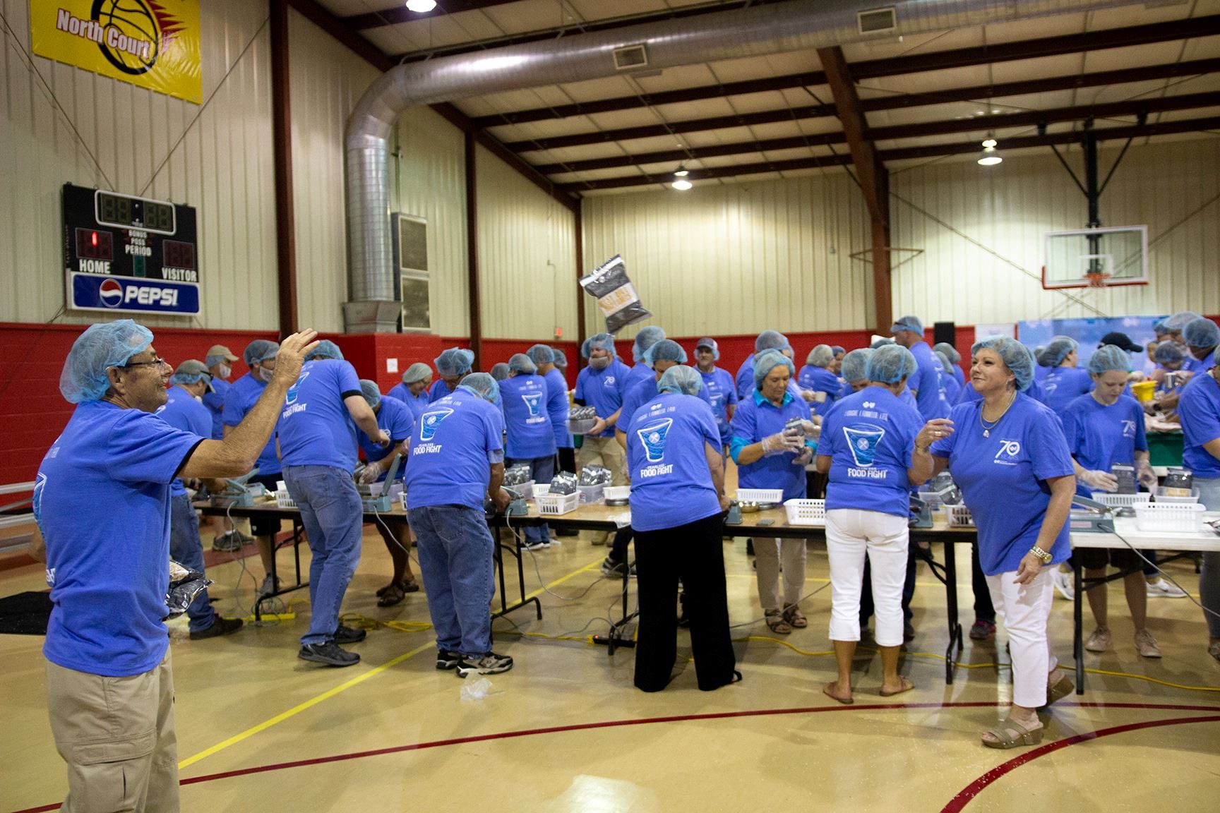 City employees bag food in an assembly line.