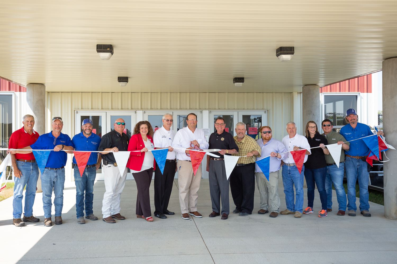 Mayor Perrin and Judge Marvin Day with other city and government officials hold the ribbon about to 