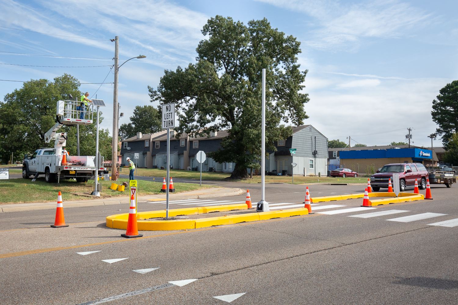 Workers add lights to the temporary pedestrian crossing on Johnson Avenue.