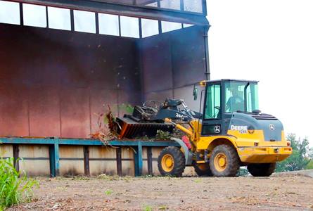 Bulldozer putting waste into incinerator