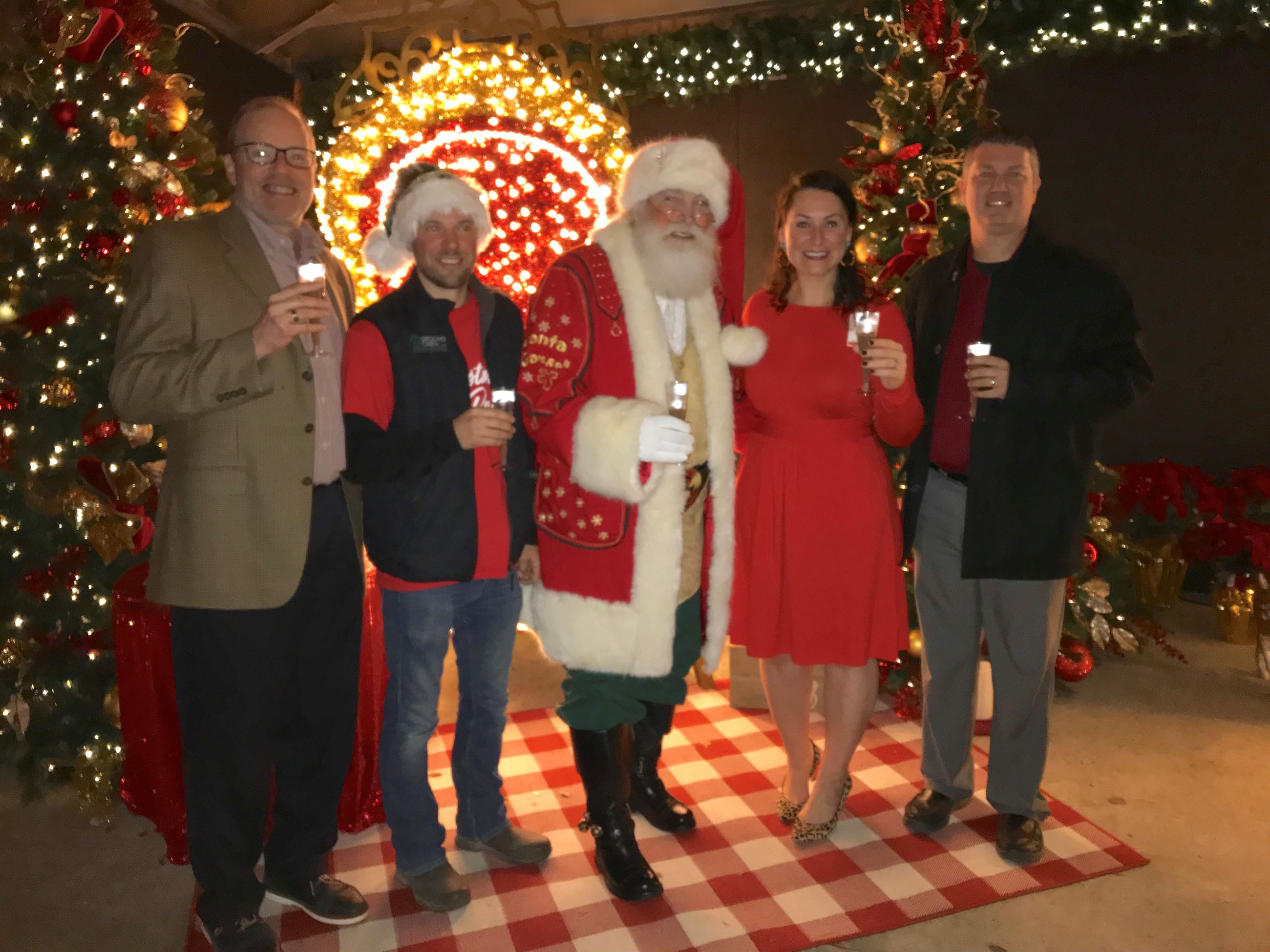 Team leaders and sponsors of Christmas at the Park pose with Santa Claus