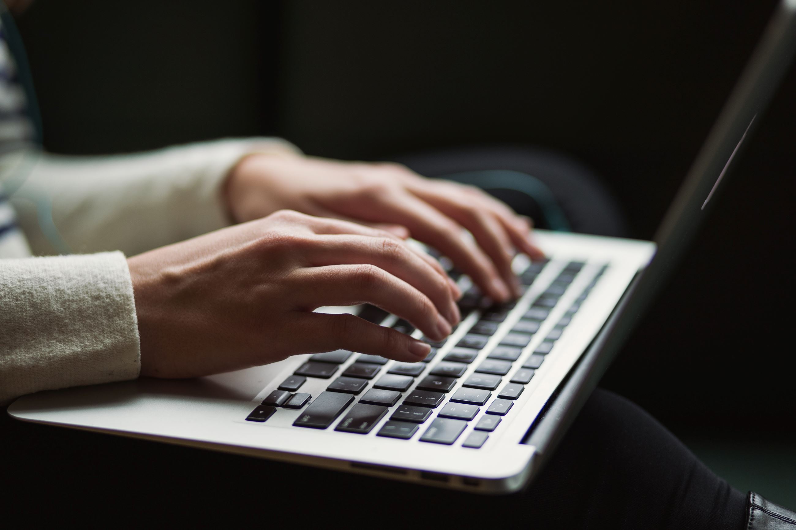 Hands typing on computer keyboard