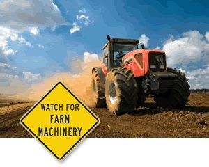 Tractor and sign that reads watch out for farm machinery