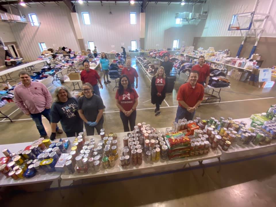 Volunteers standing amongst all the food, clothes and supplies at the donation center 