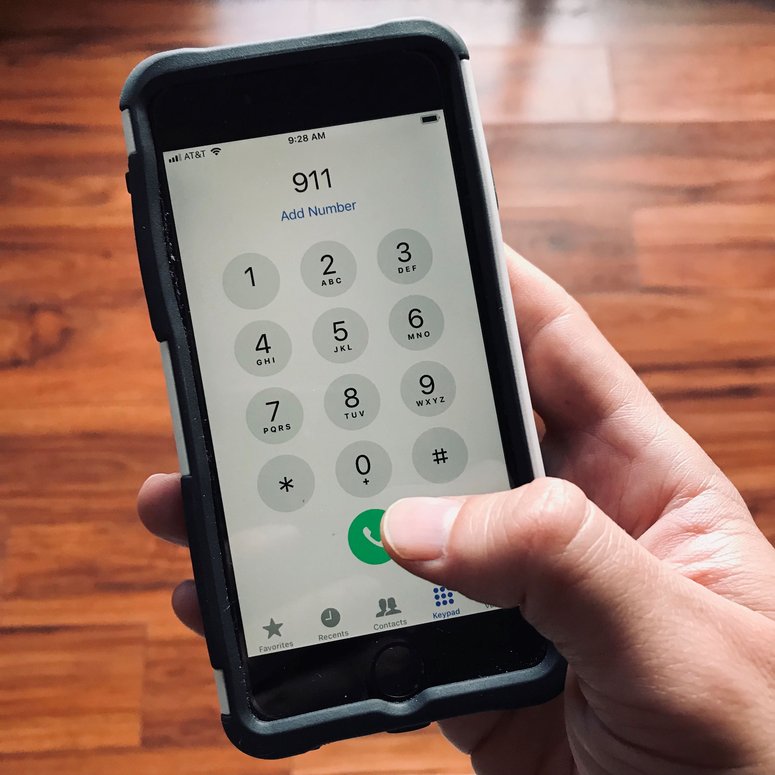 Closeup of a hand calling 911 on phone