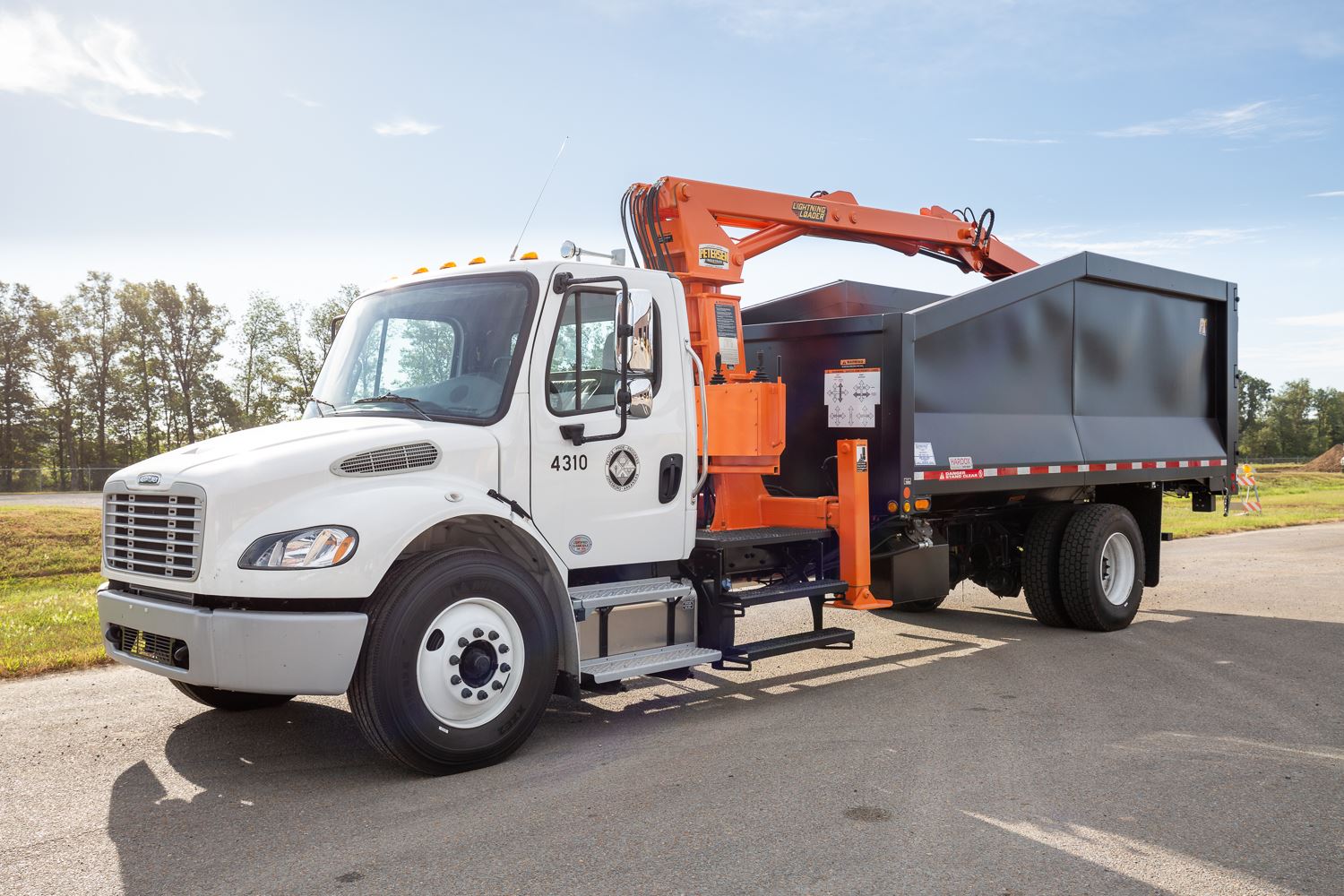 Knuckle boom truck with crane on top to pick up limbs