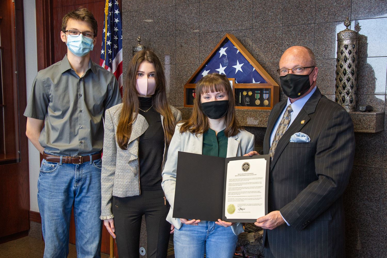 Students standing with Mayor Copenhaver and helping to hold the proclamation on paper