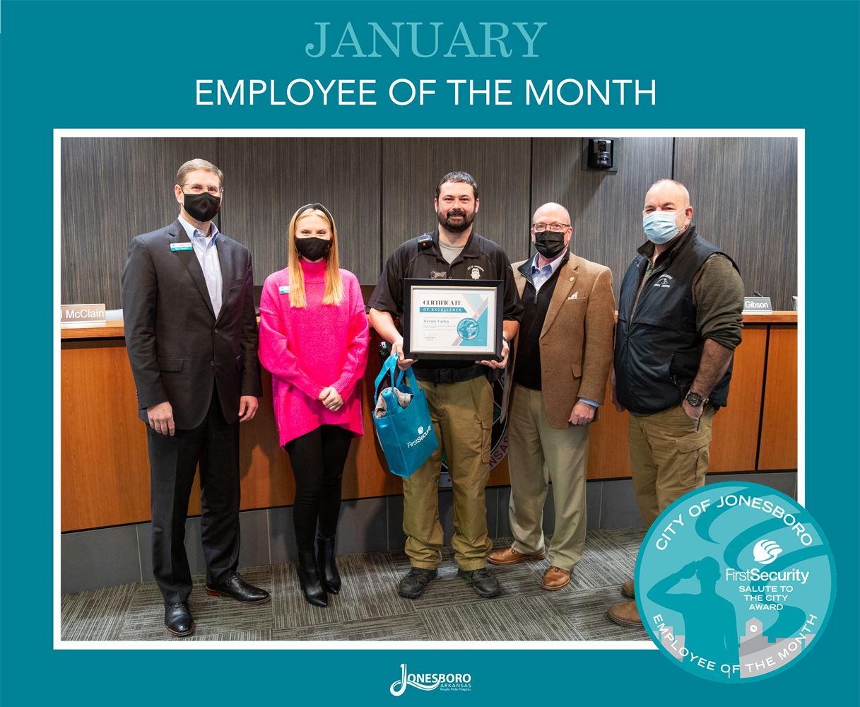 Employee of the Month Jeremy Earley holding his framed certificate and goody bag