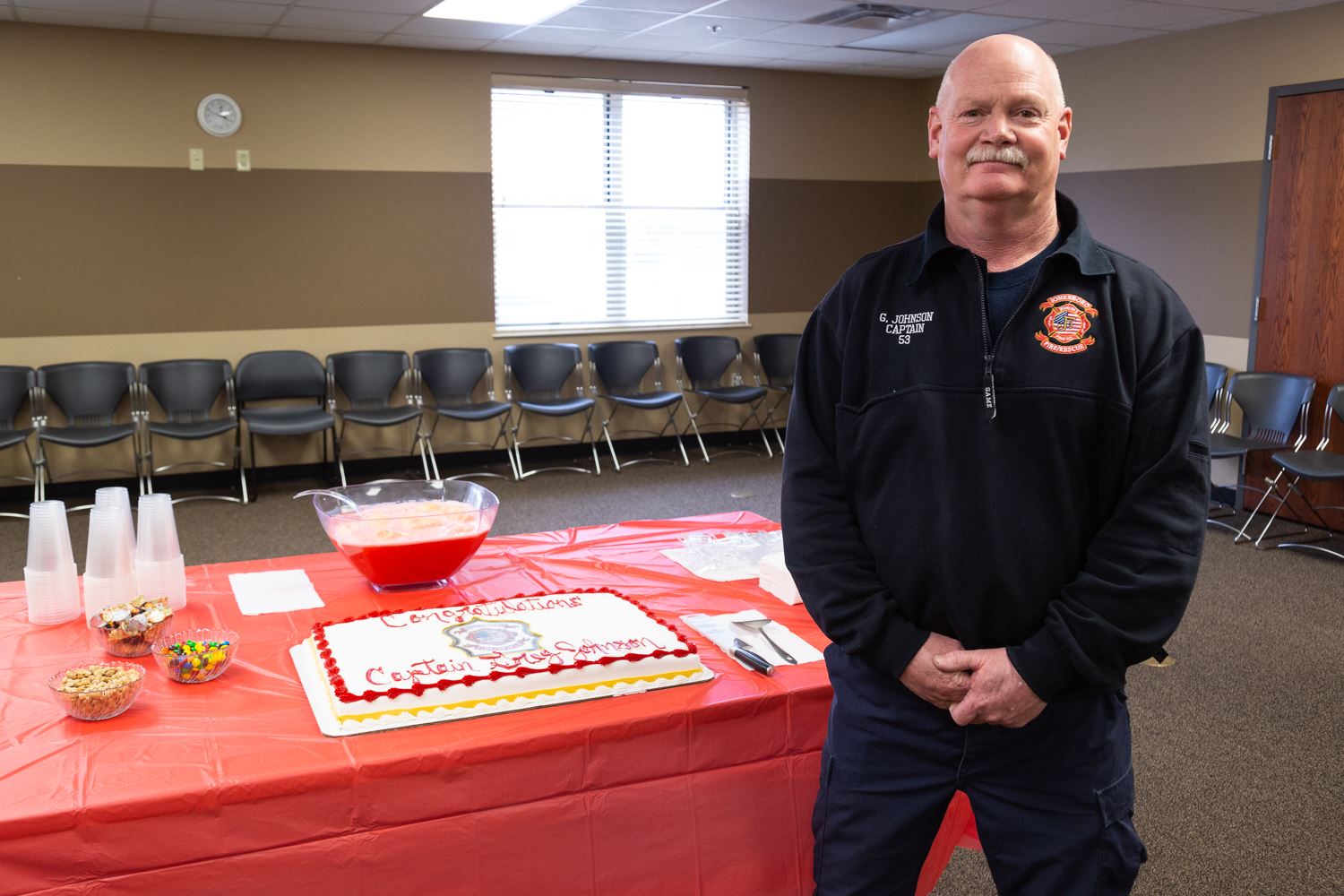 Captain Greg Johnson standing beside his cake and refreshments