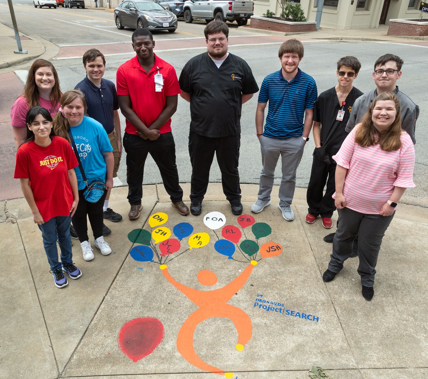 Project SEARCH interns standing around their sidewalk artwork