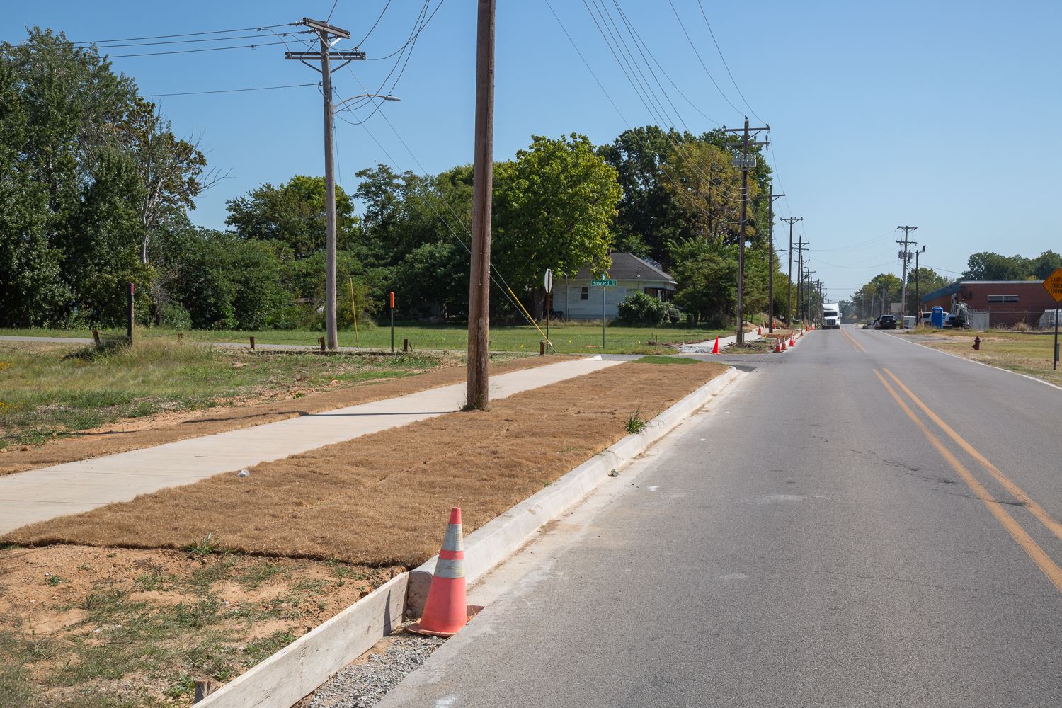 New freshly paved sidewalk stretching down side of Aggie Road